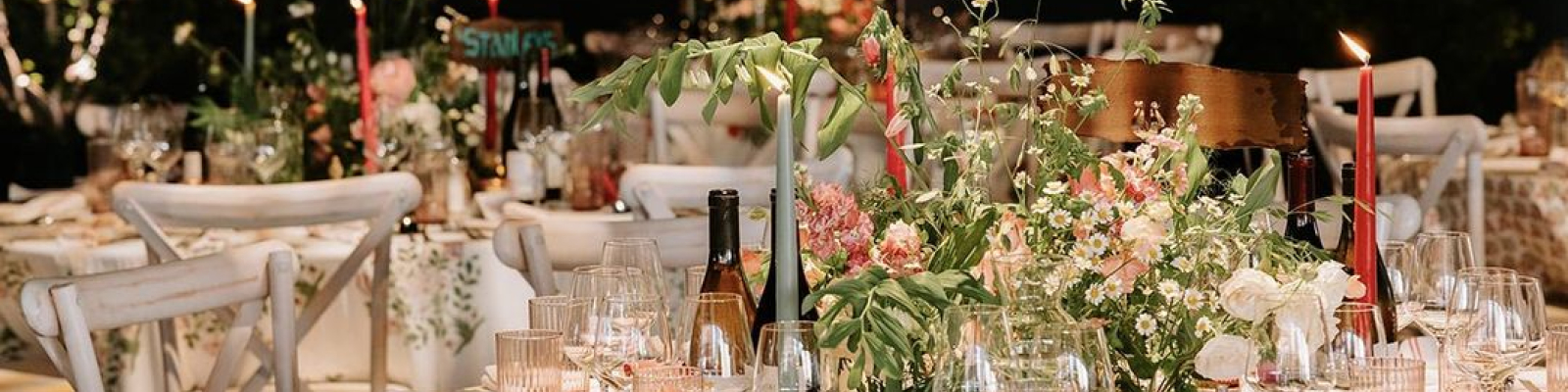 Tables for a wedding decorated with flowers, candles and wine glasses