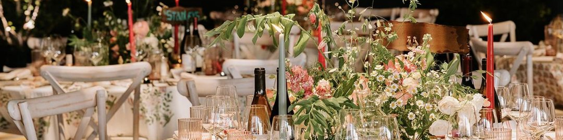 Tables for a wedding decorated with flowers, candles and wine glasses